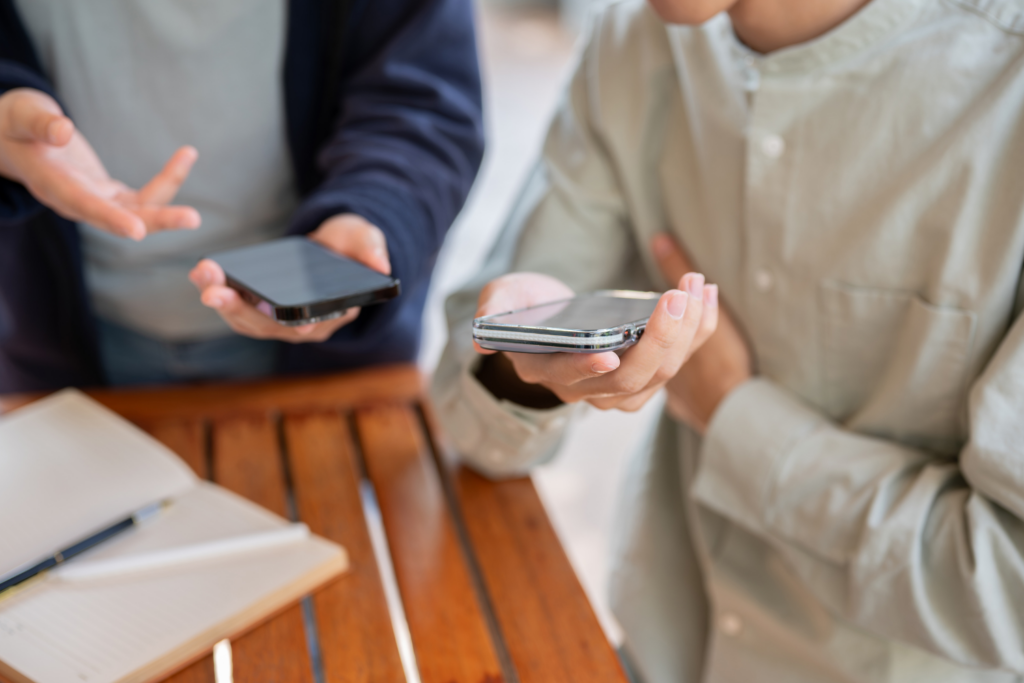 People exchanging their contacts on their phones at a networking event